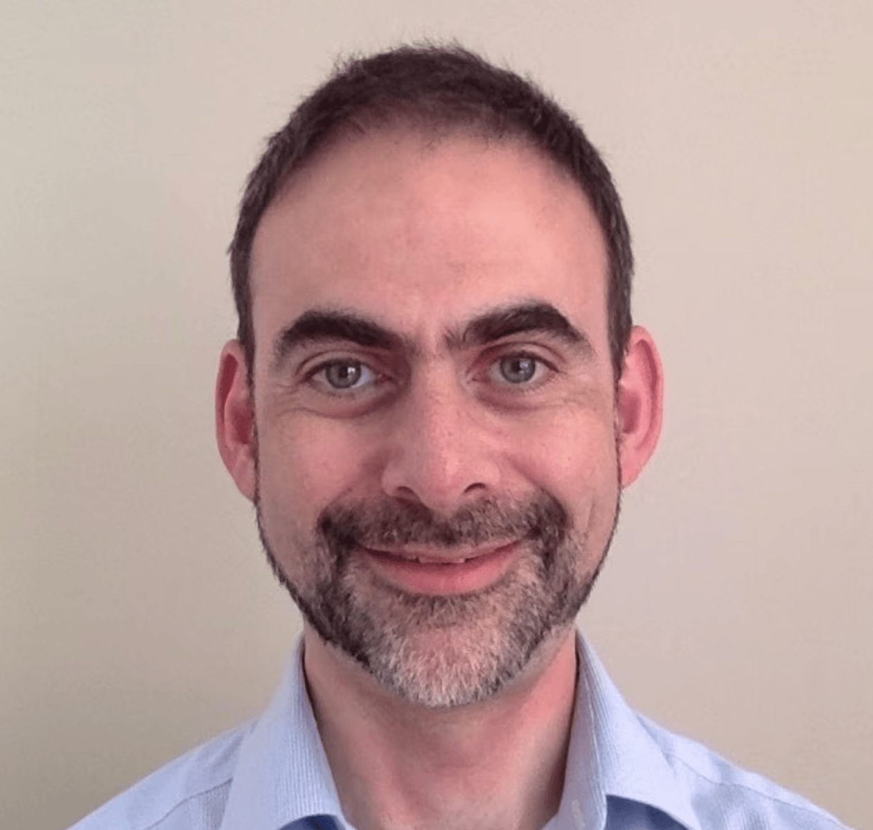 Headshot of a smiling white man with short brown hair and short beard. 